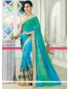 Aspiring Blue And Sea Green Patch Border Work Faux Georgette Shaded Saree